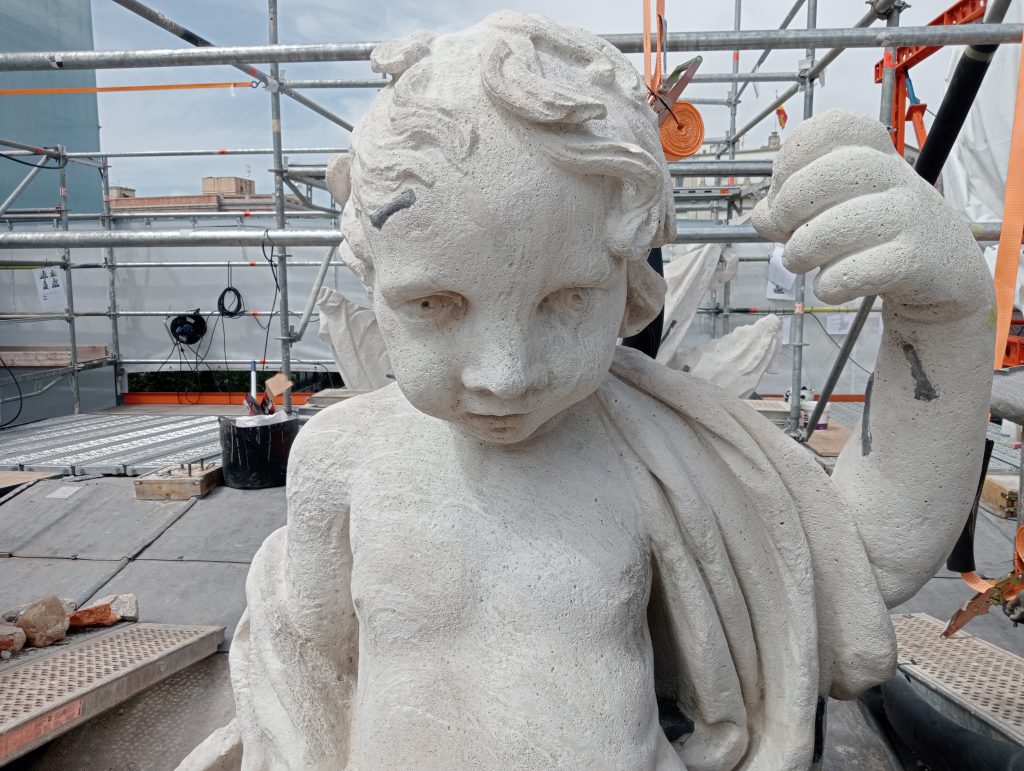 escultura blanca de niño entre andamios