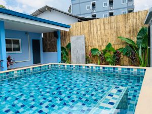 piscina con azulejos azules por fuera de una casa